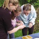 Community archaeologist showing archaeological objects to children. Courtesy of Gloucestershire County Council Archaeology Service