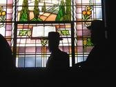 Silhouettes of men against a stained glass window at the New Synagogue, Egerton Road © Boris Baggs/English Heritage